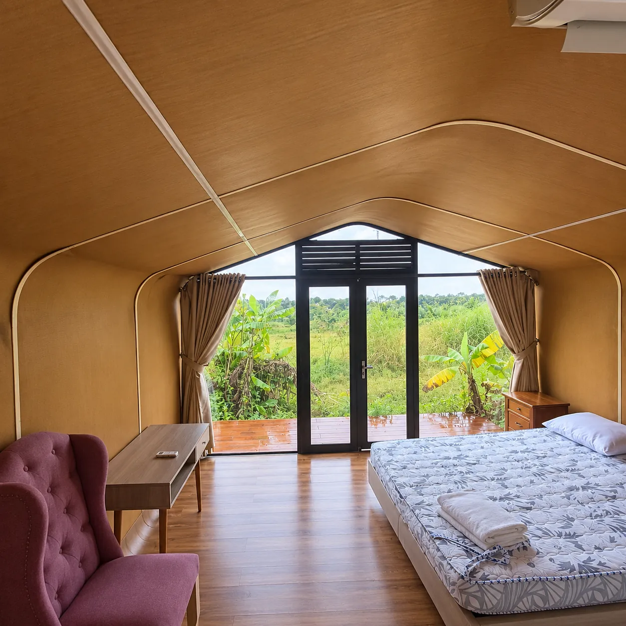 Phòng ngủ bungalow với cửa kính mở ra hiên gỗ và vườn